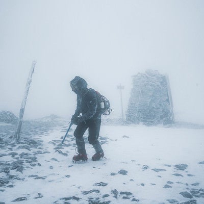 雪山の暴風に晒される登山者の写真