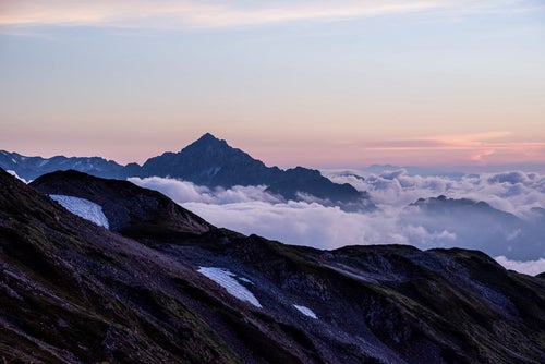 夕焼け色に染まる剱岳の写真