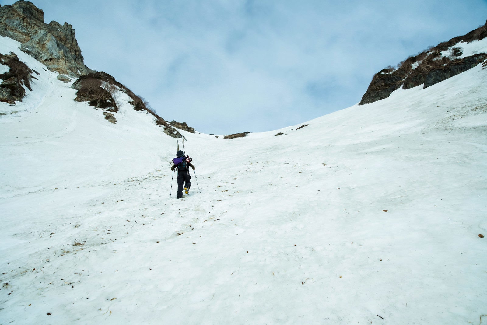 「雪山の斜面を山スキーする人」の写真