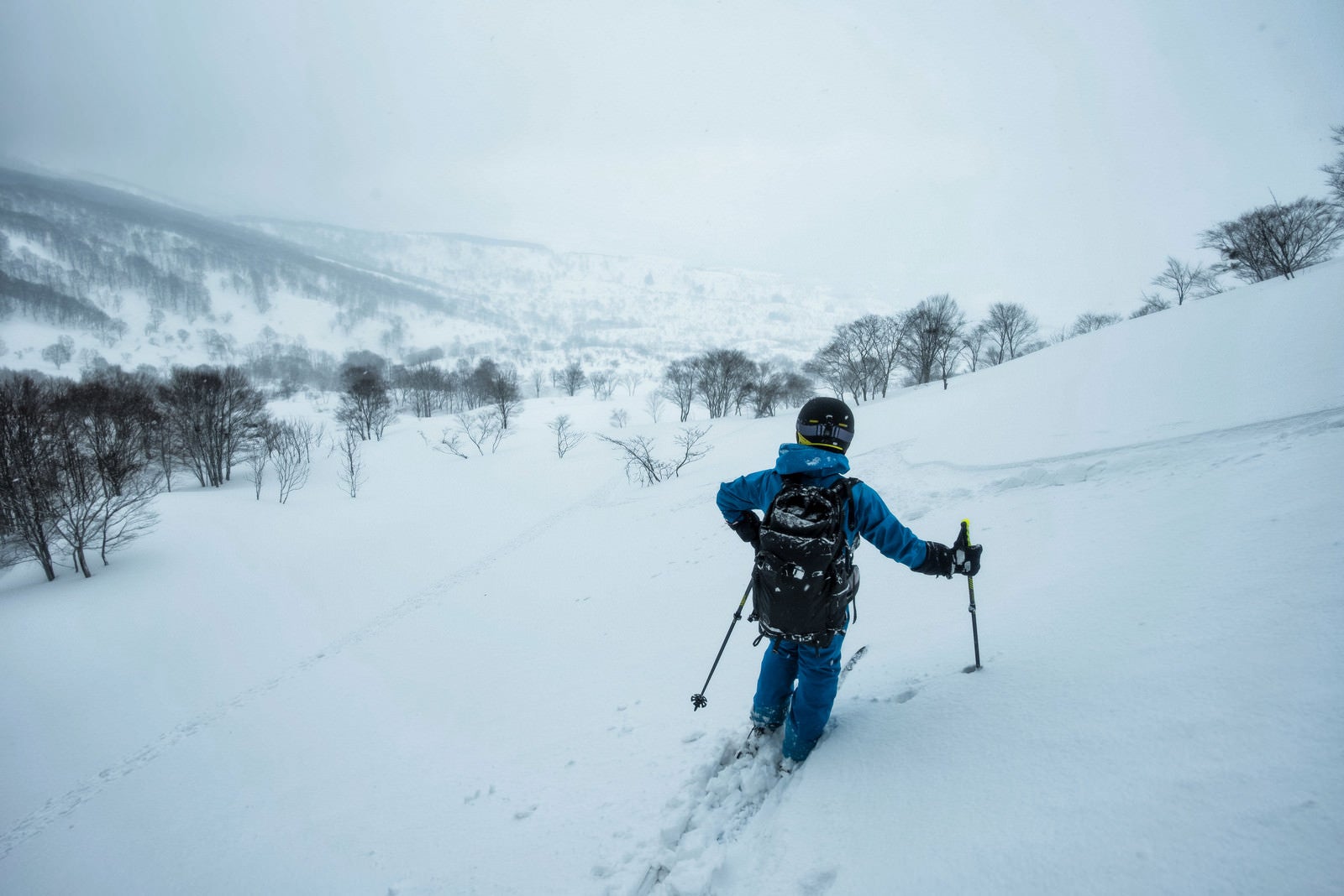 「雪深い斜面を滑るスキーヤー」の写真