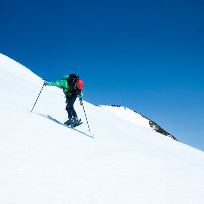 斜面を登る山スキーヤーの写真