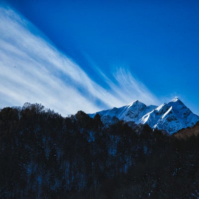 冬山から続く巻雲の写真