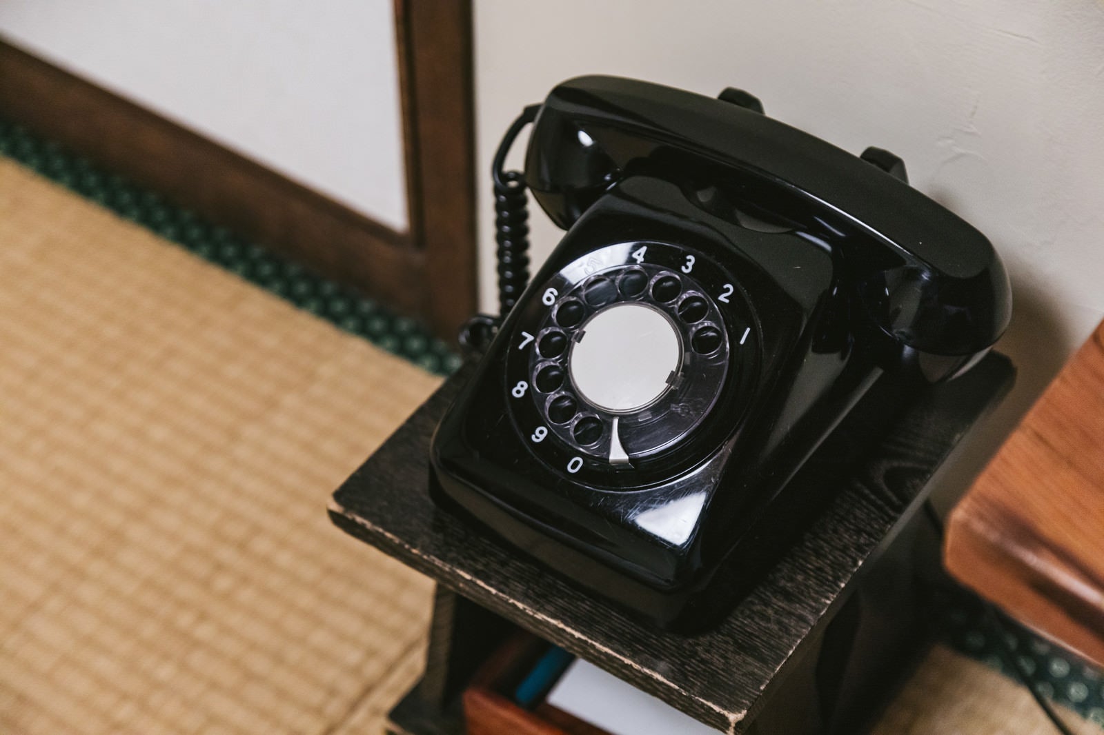 「和室の片隅に置かれた黒電話」の写真