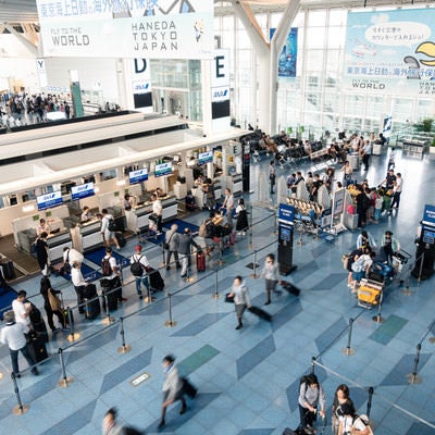 手荷物カウンターに並ぶ人（羽田空港）の写真