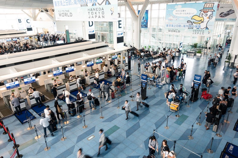 手荷物カウンターに並ぶ人（羽田空港）の写真