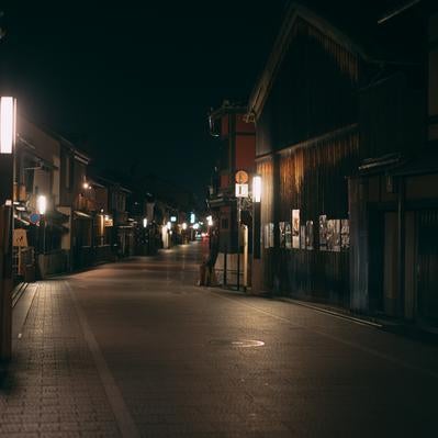 京都祇園の石畳道に温かな街灯が照らす静寂な夜の風景の写真