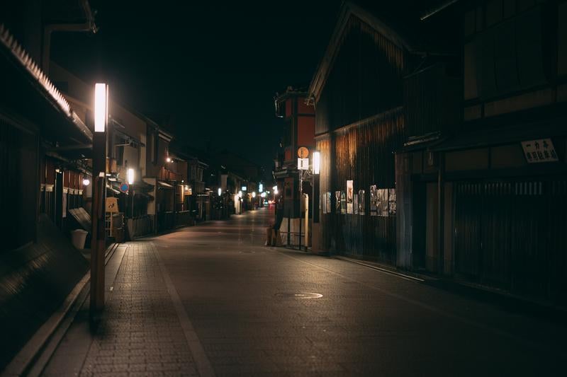 京都祇園の石畳道に温かな街灯が照らす静寂な夜の風景の写真