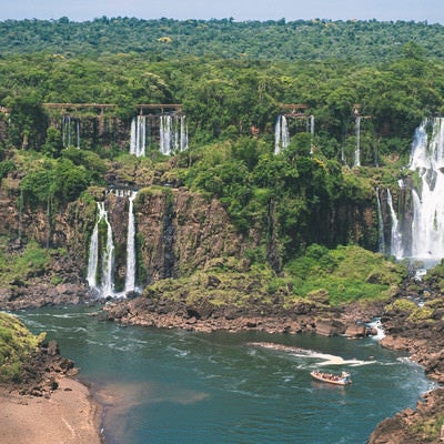ジャングルに覆われたイグアス川と観光ボート（南米大陸）の写真