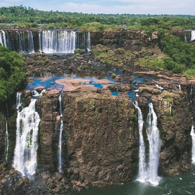 雄大な岩壁を流れ落ちるイグアスの滝（南米大陸）の写真