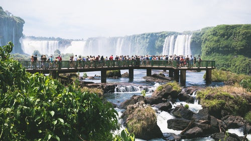 歩道橋に押し寄せる観光客とイグアスの滝（南米大陸）の写真