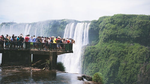 滝を覗き込むツアー客の集団（イグアスの滝）の写真