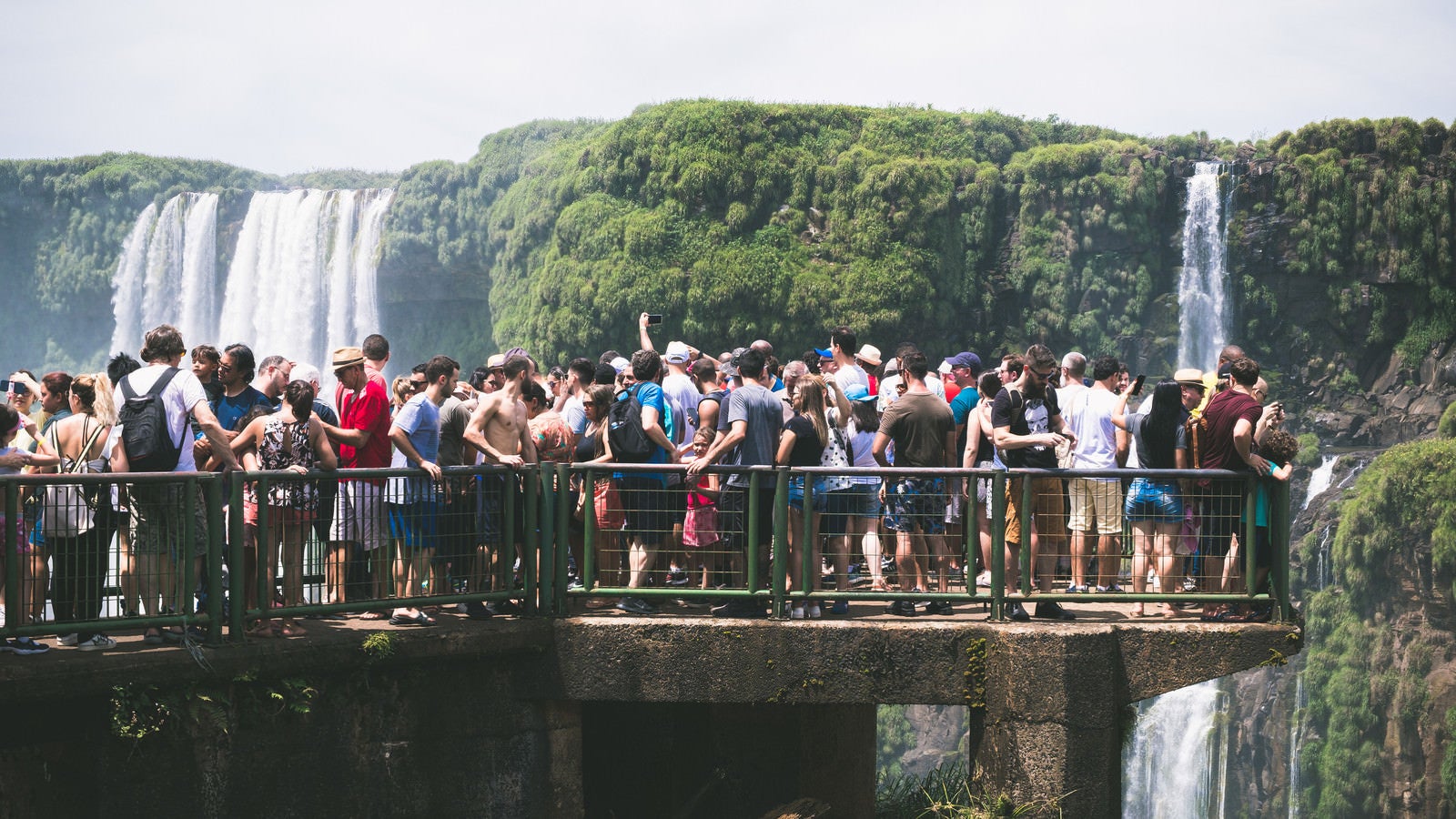 「滝の上の遊歩道に群がるツアー客（南米大陸）」の写真