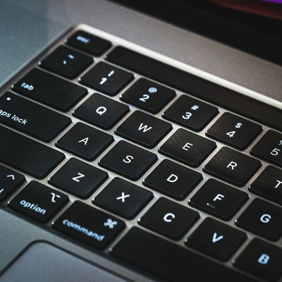 光に照らされるキーボード（Macbook）の写真