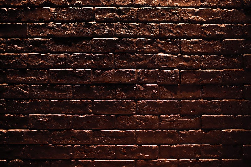 暗闇に浮かび上がるレンガの壁（テクスチャー）の写真