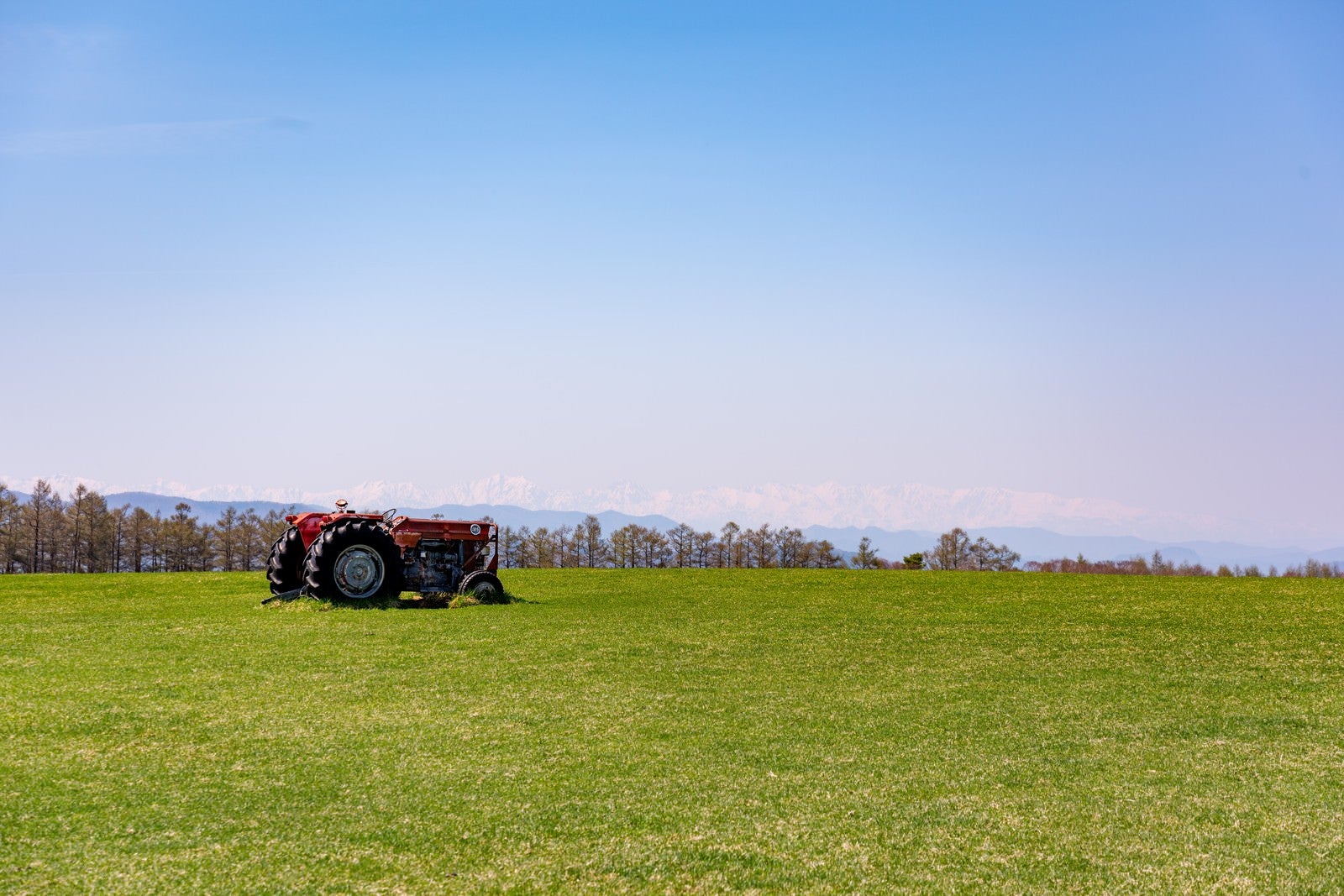 「広大な牧草地とトラクター」の写真