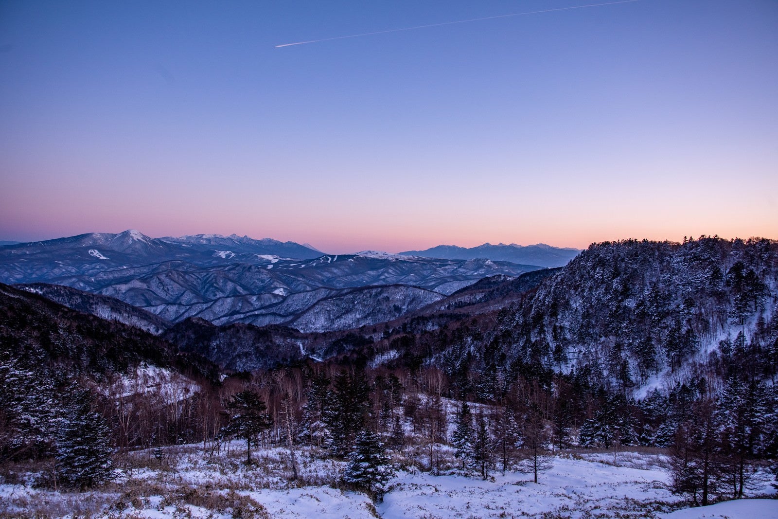 「夕暮れの空と雪山」の写真