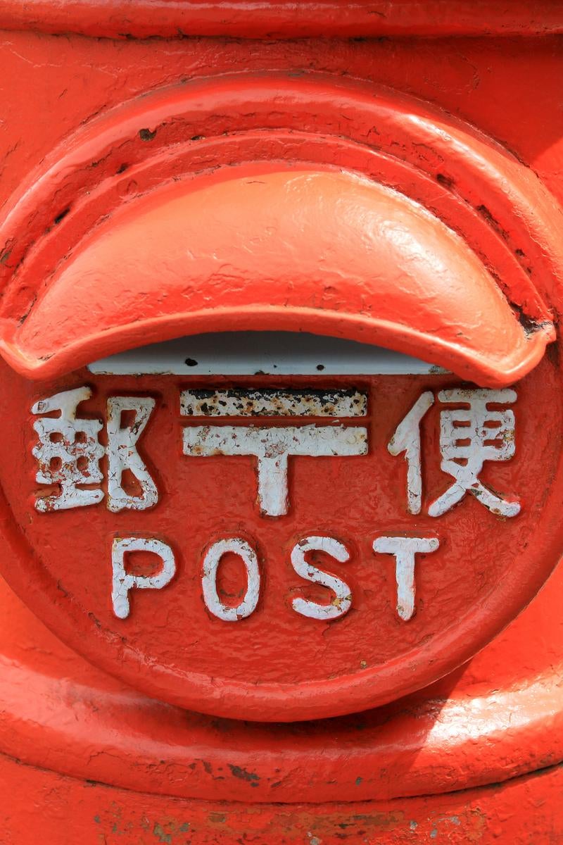 レトロな赤い丸型郵便ポストのクローズアップの写真