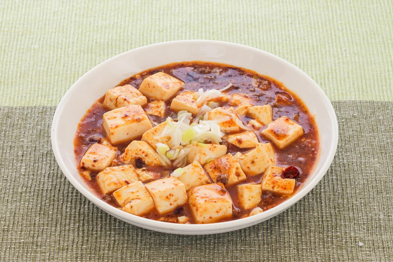 「刻みネギをトッピングした熱々の手作り麻婆豆腐」の写真