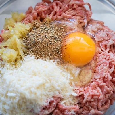 ハンバーグを作るのに合い挽き肉や卵などの材料をボウルに入れるの写真