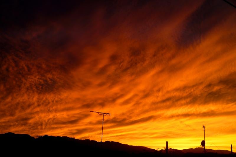 オレンジ色に染まった夜空と放送用アンテナのシルエット