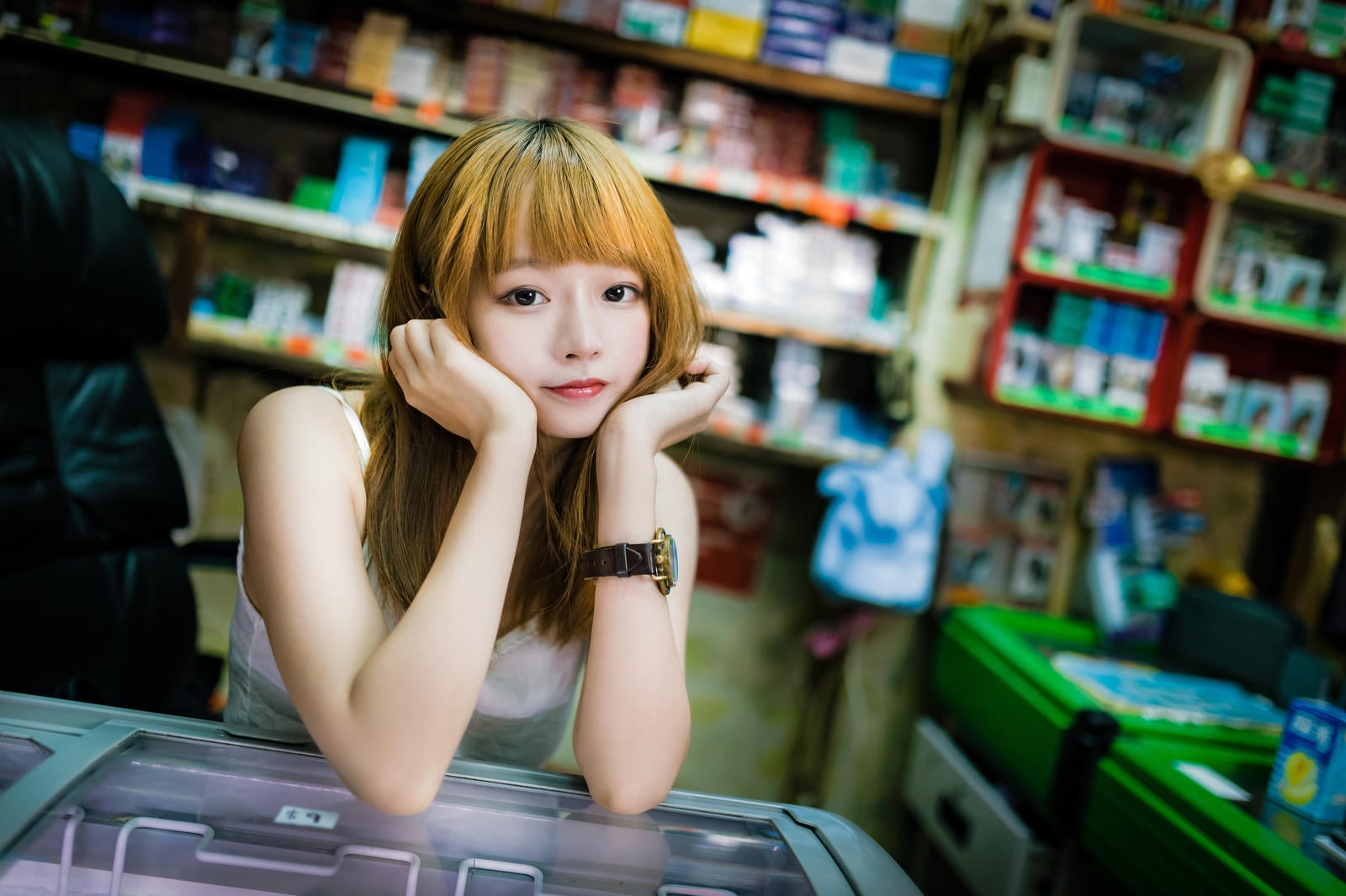「香港の商店で店番をするプリン髪の美少女」の写真