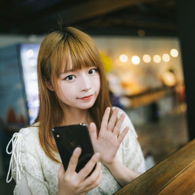 おまたせー道に迷っちゃってーとスマートフォンを確認するカフェでの待ち合わせの写真