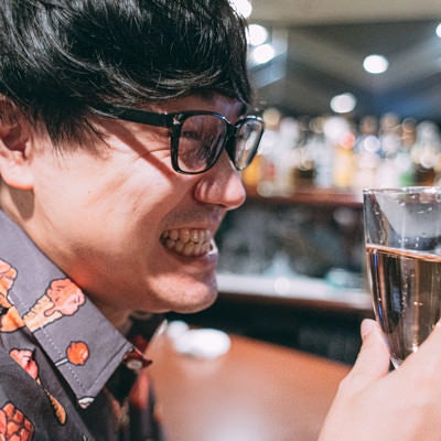 シャンパンで乾杯する眼鏡の男性の写真