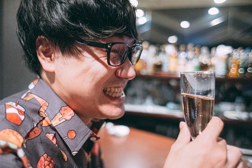 シャンパンで乾杯する眼鏡の男性の写真