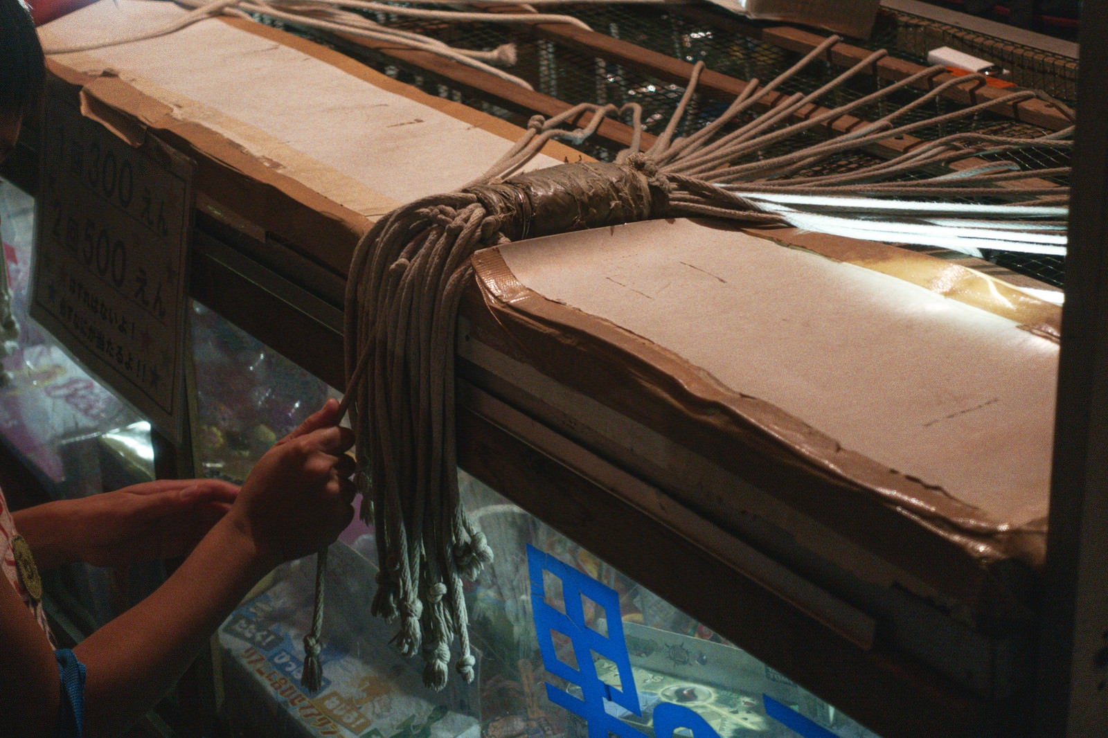 「お祭りの出店で紐のうち1本を引くと吊るされた商品がもらえる系のくじ引き（千本引き）」の写真