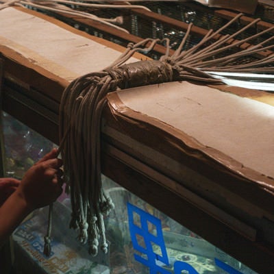 お祭りの出店で紐のうち1本を引くと吊るされた商品がもらえる系のくじ引き（千本引き）の写真