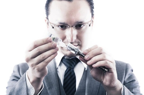 電子タバコにリキッドを補充するビジネスマンの写真
