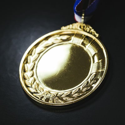 照明が反射した金メダルの写真