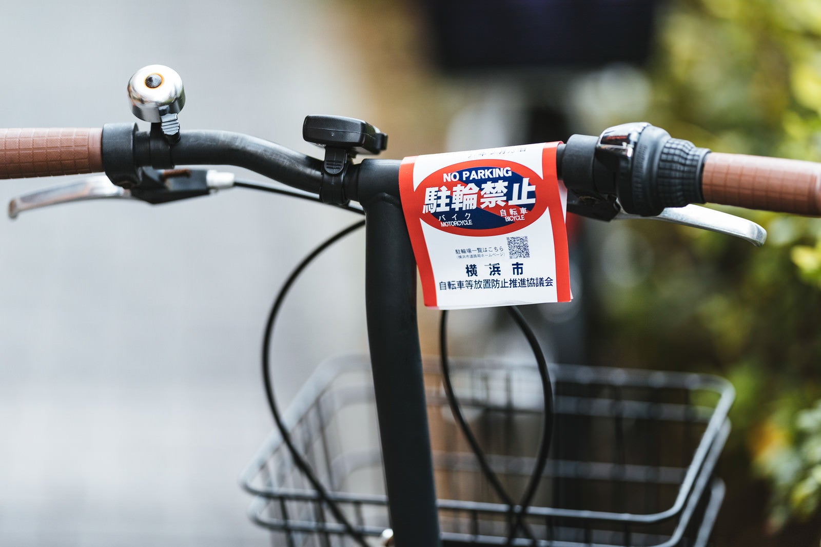 「自転車のハンドルに付けられた駐輪禁止の警告書」の写真