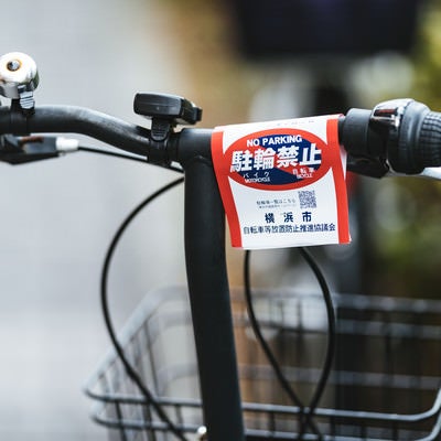 自転車のハンドルに付けられた駐輪禁止の警告書の写真