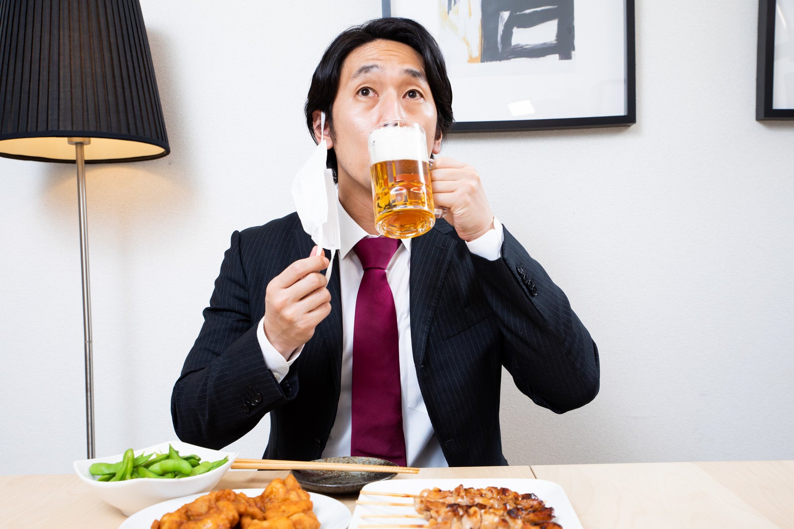 「マスクをずらして生ビールを飲む会社員」の写真［モデル：大川竜弥］