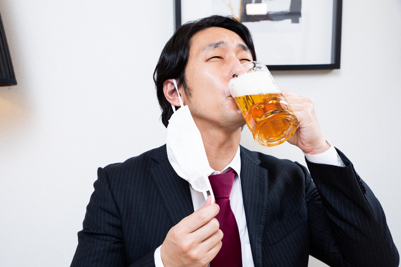 「マスクを外して生ビールを飲むサラリーマン」の写真［モデル：大川竜弥］