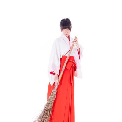 竹箒（たけぼうき）で掃除中の巫女さんの写真