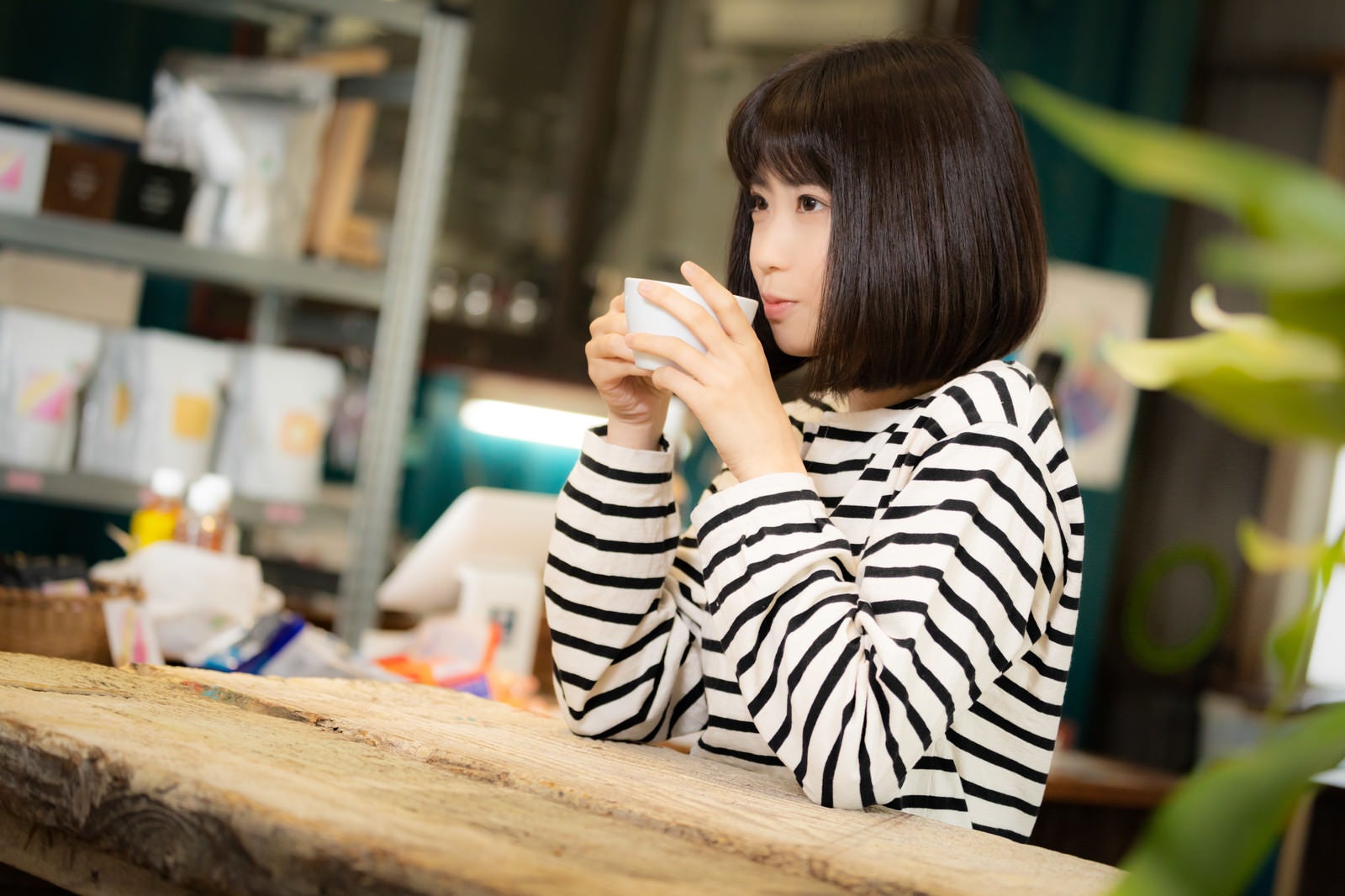 「挽きたてのコーヒーを飲む女性」の写真［モデル：塩田みう］