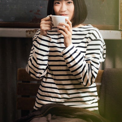 コーヒーで温まる女性の写真