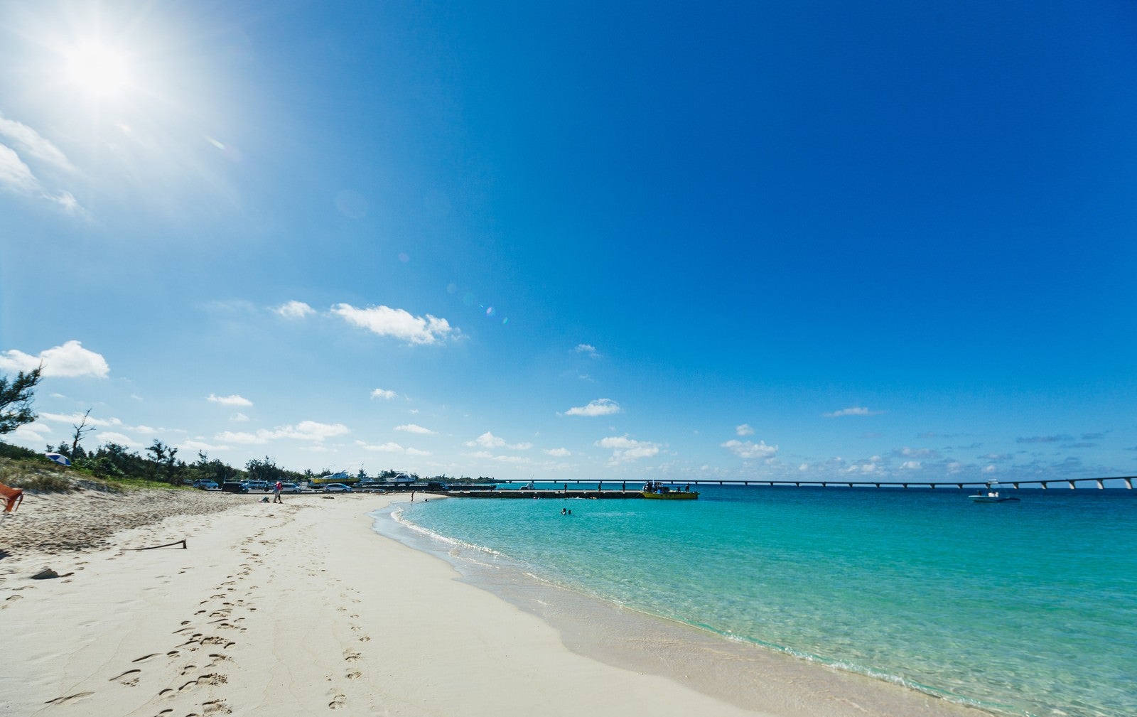 「透き通る青い空と浜辺に残る足跡」の写真