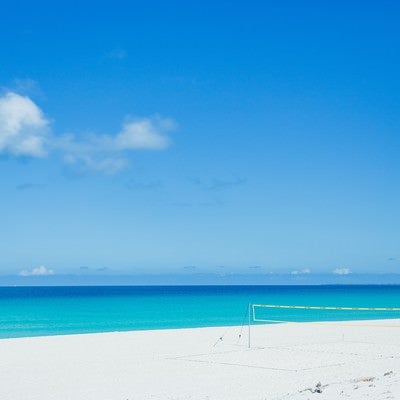 白い砂浜に用意されたビーチバレーネットの写真
