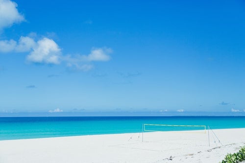 白い砂浜に用意されたビーチバレーネットの写真