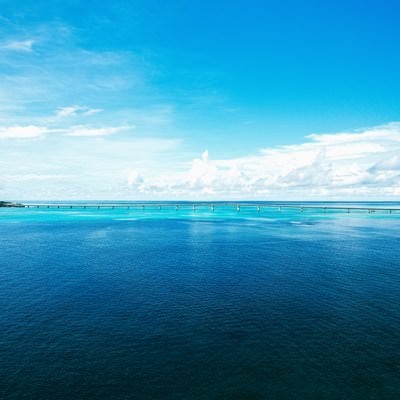 宮古島から望む伊良部大橋と透明度のエメラルドブルーの海の写真
