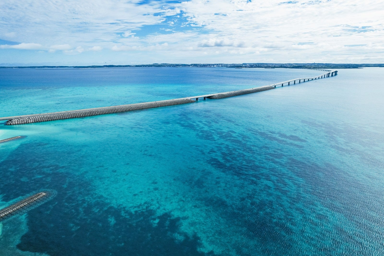 宮古島の透き通った海上に架かる伊良部大橋を上空から撮影した風景写真