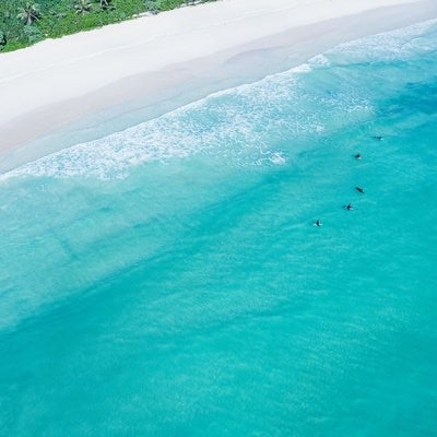 透明度の高い宮古島の海に浮かぶサーファーの写真