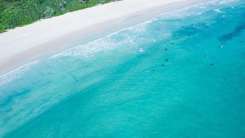 透明度の高い宮古島の海に浮かぶサーファーの写真