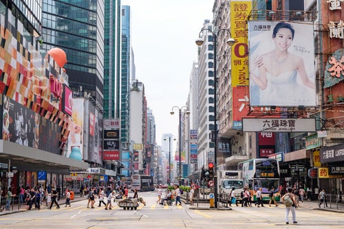 香港の都市部の景観と横断する人々の写真