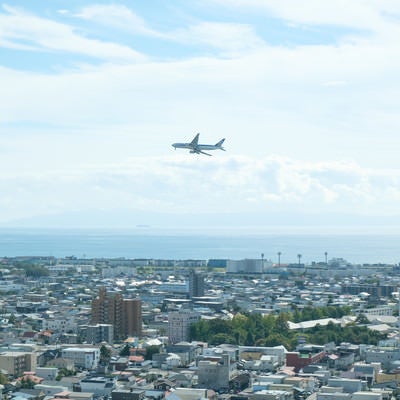 市街地の上空を旋回する旅客機の写真