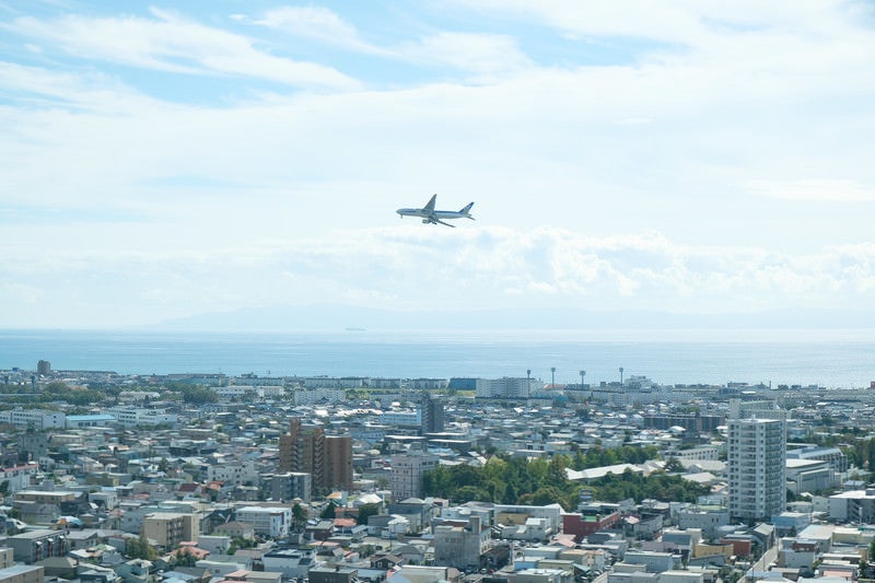 市街地の上空を旋回する旅客機の写真