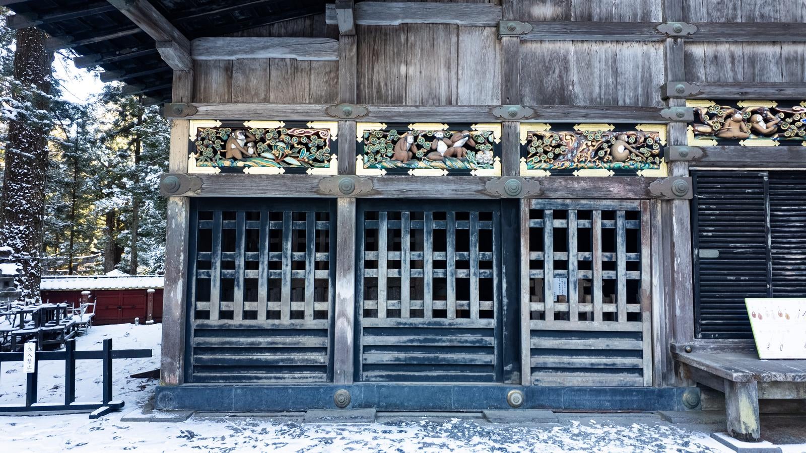 雪が積もった日光東照宮の木造建築に施された彫刻装飾と格子戸